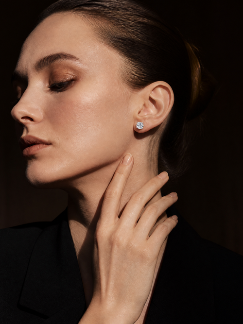 J&Y moissanite stud earrings featuring sparkling gemstone set in a silver-tone metal, close-up view of the elegant jewelry.